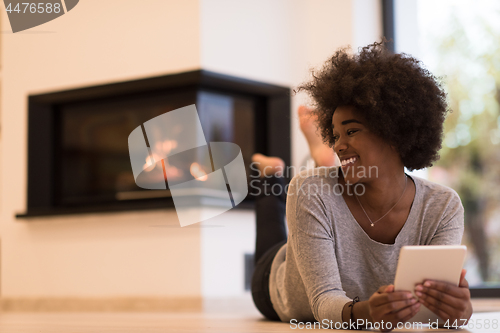 Image of black women using tablet computer on the floor