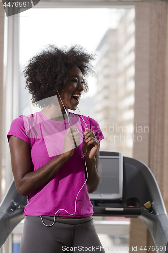 Image of afro american woman running on a treadmill