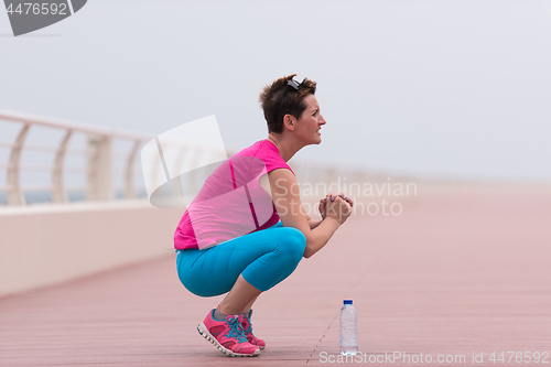 Image of woman stretching and warming up on the promenade