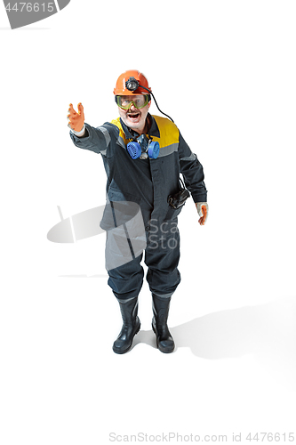 Image of The studio shot of senior bearded male miner standing at the camera on a white background.