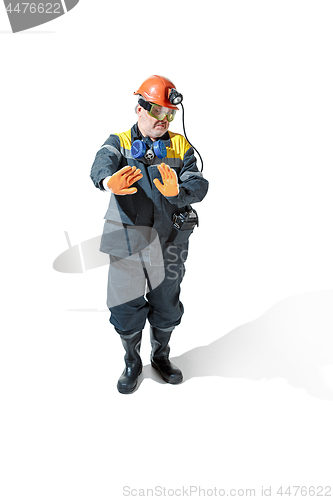 Image of The studio shot of senior bearded male miner standing at the camera on a white background.