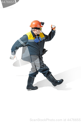 Image of The studio shot of senior bearded male miner standing at the camera on a white background.