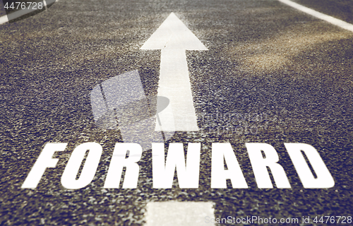 Image of close up of arrow and word forward on asphalt road