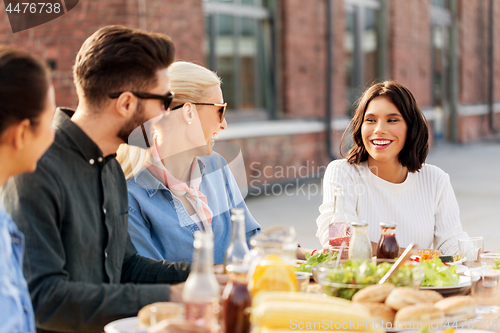 Image of friends having dinner or bbq party on rooftop