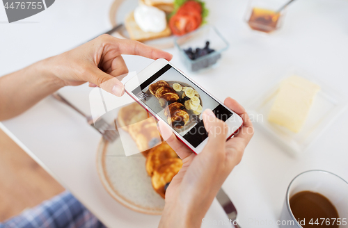 Image of hands with smartphones photographing food