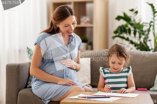 Image of pregnant mother and daughter drawing at home