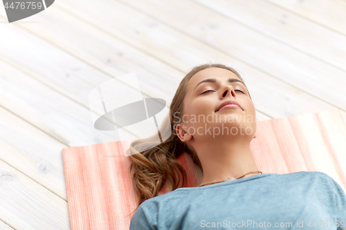 Image of woman doing yoga corpse pose at studio