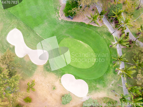 Image of Birds eye view of golf course hole green and sand traps.