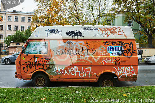 Image of Old broken orange van completely riddled with graffiti