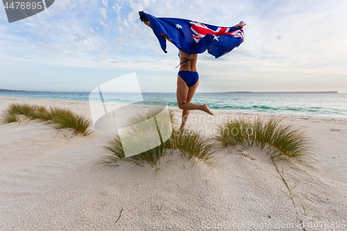 Image of Woman running and leaping with Australian Flag