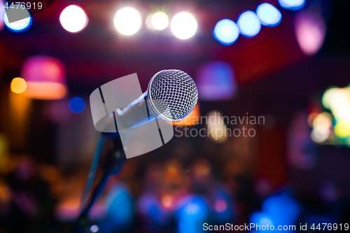 Image of Microphone on stage against a background of auditorium.