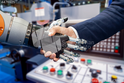 Image of Hand of a businessman shaking hands with a Android robot.