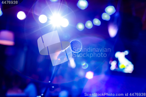 Image of Microphone on stage against a background of auditorium.