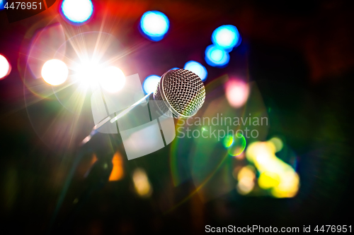 Image of Microphone on stage against a background of auditorium.