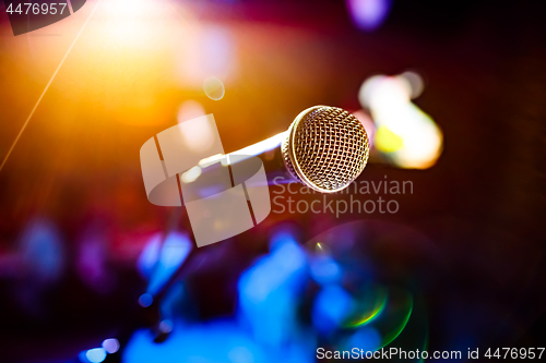 Image of Microphone on stage against a background of auditorium.