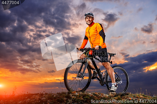 Image of Man in helmet and glasses stay on the bicycle