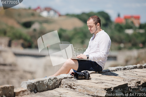 Image of Man using a modern portable computer on the park