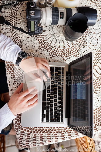 Image of man working with laptop computer and sitting on sofa