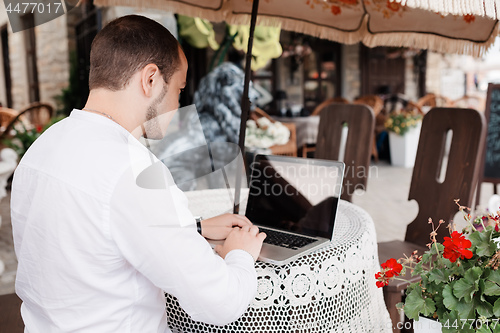 Image of man internet browsing at the cafe bar.