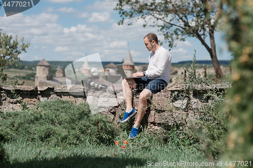 Image of Man using a modern portable computer on the park