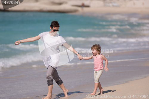 Image of mother and daughter running on the beach