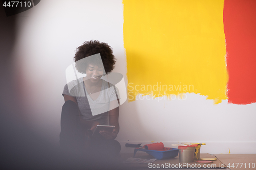 Image of back female painter sitting on floor