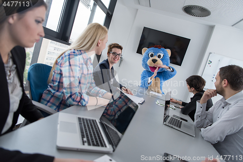 Image of boss dresed as bear having fun with business people in trendy of