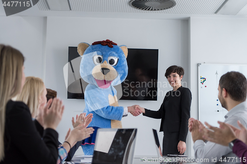 Image of boss dresed as bear having fun with business people in trendy of