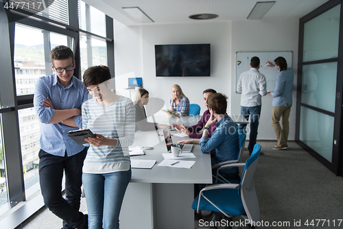 Image of Two Business People Working With Tablet in office