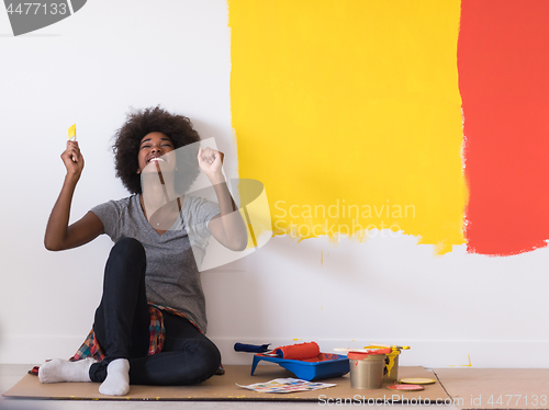 Image of back female painter sitting on floor