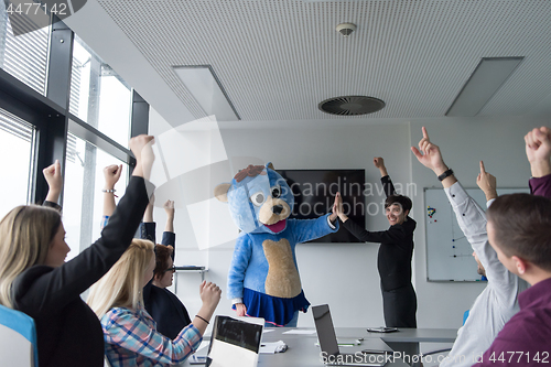 Image of boss dresed as bear having fun with business people in trendy of