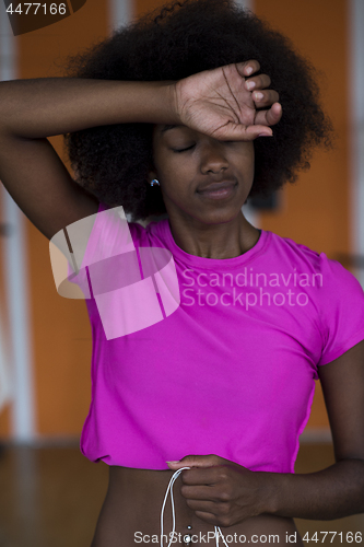 Image of afro american woman running on a treadmill