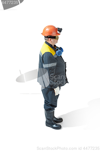 Image of The studio shot of senior bearded male miner standing at the camera on a white background.