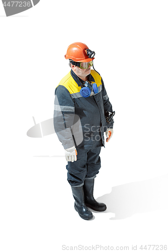 Image of The studio shot of senior bearded male miner standing at the camera on a white background.