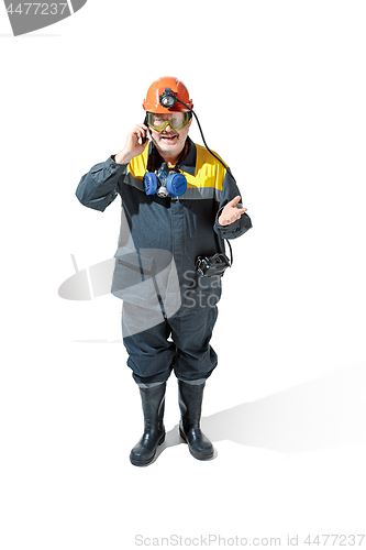 Image of The studio shot of senior bearded male miner standing at the camera on a white background.