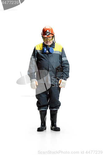 Image of The studio shot of sad senior bearded male miner standing at the camera on a white background.