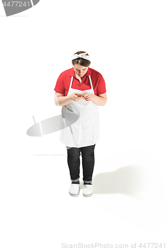 Image of Portrait of cute smiling woman with mobile phone in her hands in the studio, isolated on white background