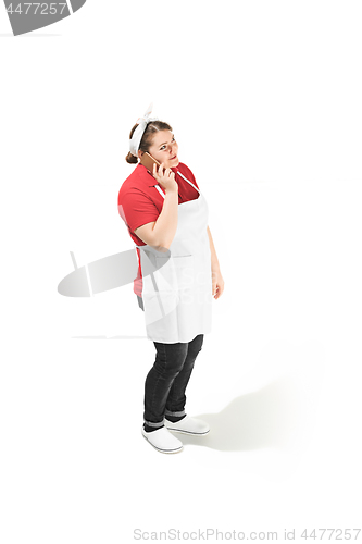 Image of Portrait of cute smiling woman with mobile phone in her hands in the studio, isolated on white background