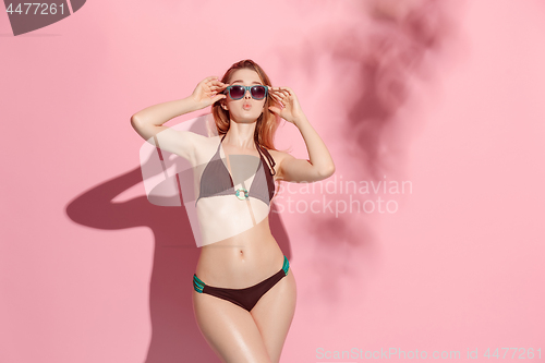 Image of Beautiful female model posing on pink background