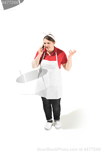 Image of Portrait of cute smiling woman with mobile phone in her hands in the studio, isolated on white background