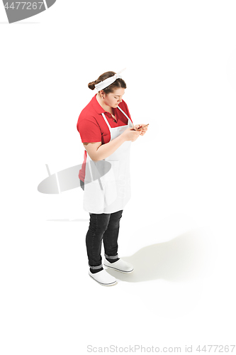 Image of Portrait of cute smiling woman with mobile phone in her hands in the studio, isolated on white background