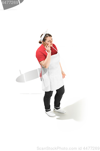 Image of Portrait of cute serious woman with mobile phone in her hands in the studio, isolated on white background