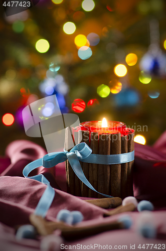 Image of Candle on the background of decorated spruce.