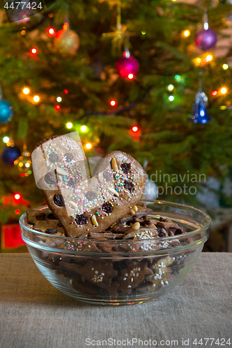 Image of Gingerbread heart on decorated spruce background.