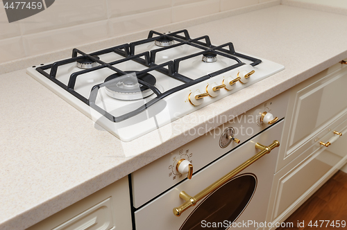 Image of Gas stove and oven at cream colored kitchen