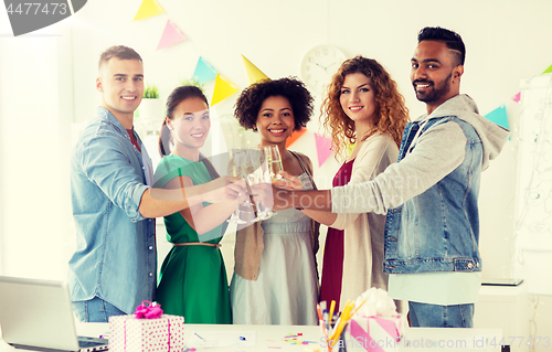 Image of happy team with champagne at office birthday party