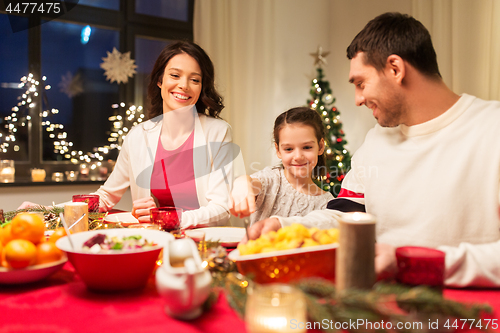 Image of happy family having christmas dinner at home