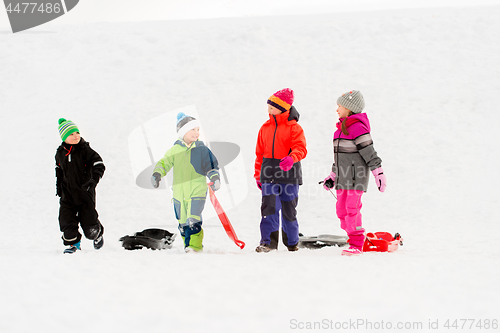 Image of happy little kids with sleds in winter