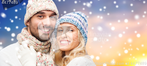 Image of smiling couple in sweaters over snow background