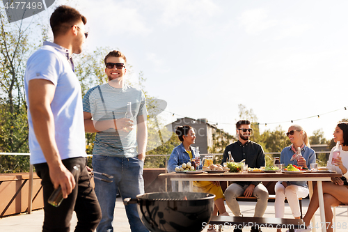 Image of happy friends having bbq party on rooftop